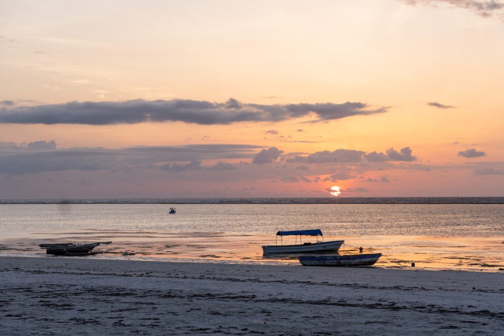 Sonnenaufgang am Strand mit Fischerbooten, Sansibar, Tansania