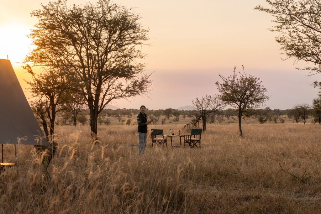Tansania im August auf Safari Sundowner-Tisch in der Savanne, Reisender bei Sonnenuntergang, Select-Zelt-Safari, Serengeti Tansania, Globetrotter Select
