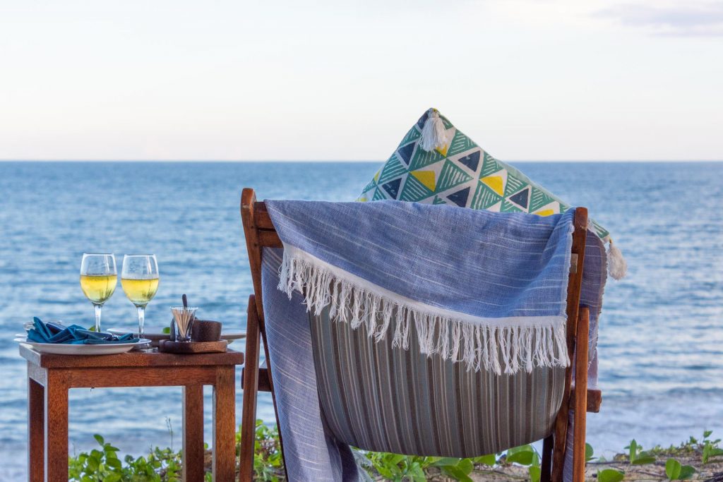 Die schönsten Ausflüge auf Sansibar Stuhl und Tisch mit Weingläsern am Strand, Sansibar Ausflüge, Tansania, Globetrotter Select